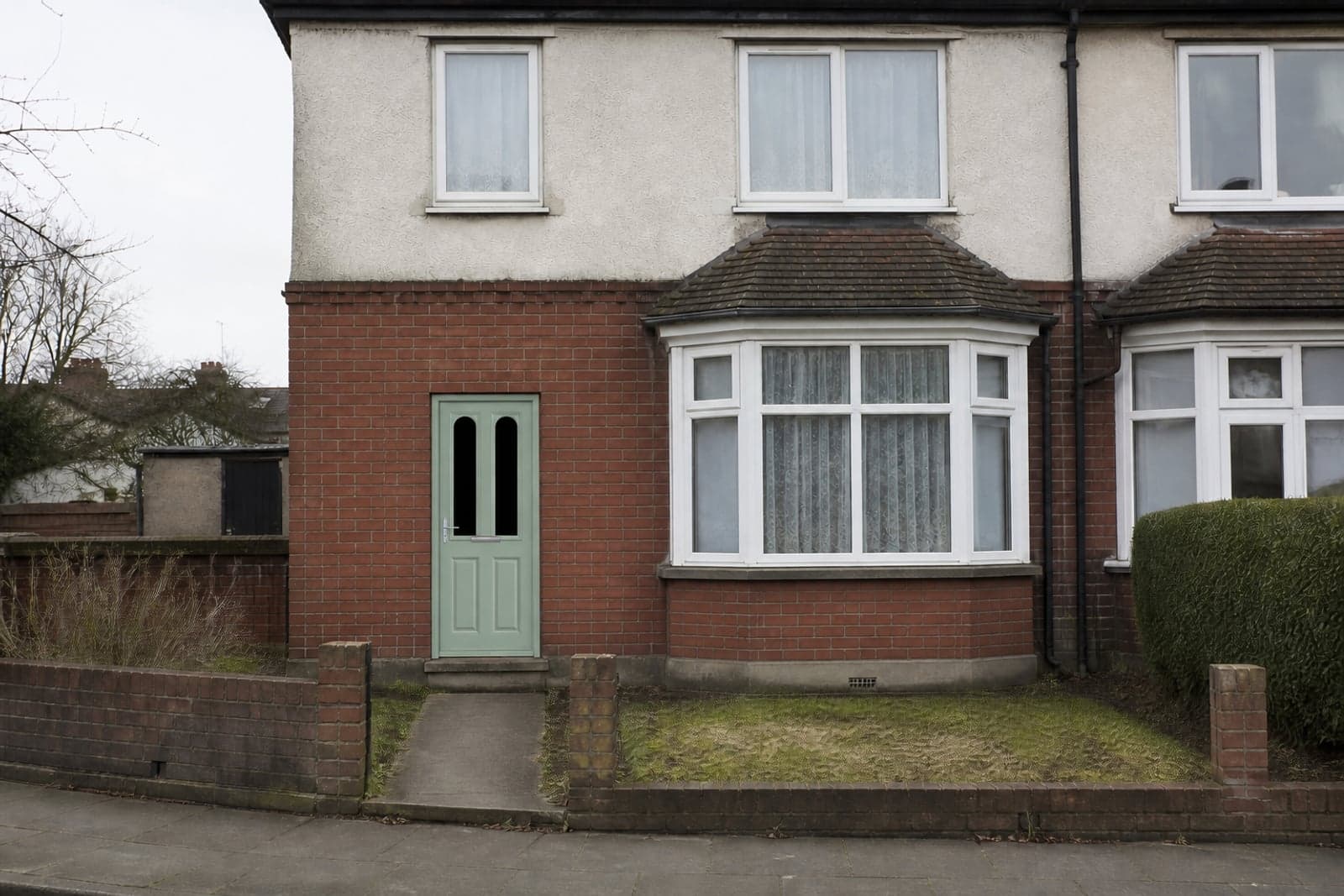 A composite front door fitted into the opening of a British semi-detached house.